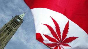 A Canadian flag with a marijuana leaf flies during a rally alongside Parliament Hill in Ottawa, Canada.