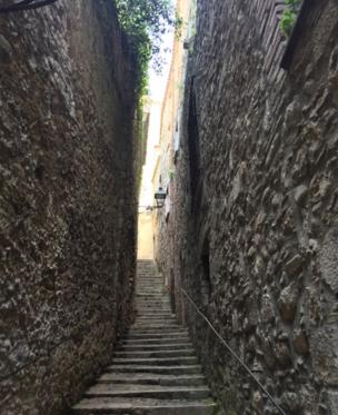 A narrow staircase between two high walls