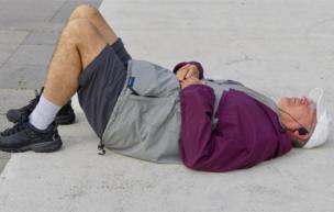 A man takes a nap on the floor