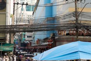A mass of communication and power cables strung above the street keeping the city connected