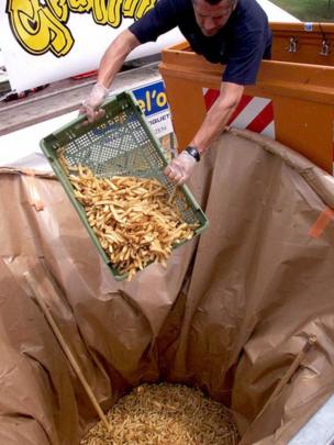 Hombre echando papas fritas a un contenedor gigante