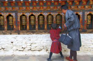 A father and son spin a prayer wheel
