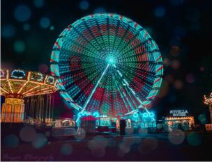 An illuminated ferris wheel at a fairground