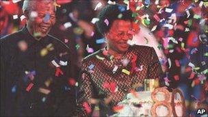 Nelson Mandela with his new wife, Graca Machel, next to his birthday cake, at a reception held at Gallagher Estate outside Johannesburg Sunday, 19 July 1998