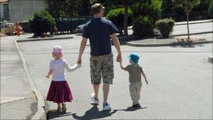 A man walks with two children