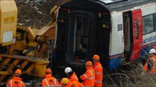 Workers surround the derailed train