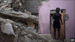 A woman stands in the remains of her home on 5 August, 2010