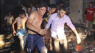 Rescuers rush victims of a bomb attack in Basra to hospital (7 August 2010)