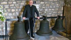 Rev Keith Evans with the three bells at All Saints Church in Mumbles