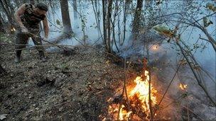 A man tries to extinguish a forest fire near Zdorovie, east of Moscow
