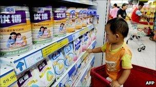 A Chinese baby looks at tins of Synutra milk powder at a supermarket in Beijing on 9 August 2010