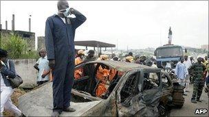 A rescue worker stands on one of the burnt vehicles at the scene of the accident on Lagos-Ibadan highway on 16 August 2010