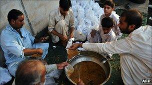 Pakistani men prepare food bags for flood-affected people in Sukkur (19 August 19 2010)