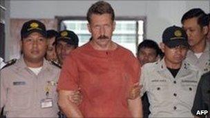 Russian alleged arms dealer, Viktor Bout, is escorted by court security guards following his verdict at the Criminal Court in Bangkok on 11 August 2009.