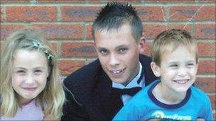 Joshua Parkin, centre, with his sister and one of his brothers