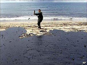 A lone volunteer clears up oil in Galicia after the Prestige spill (2002)