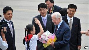 Jimmy Carter receives flowers from a North Korean child in Pyongyang on 25 August 2010