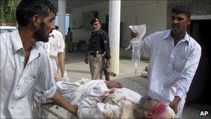 Pakistani volunteers carry an injured victim of a suicide bombing in Lakki Marwat on 6 September 2010