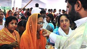 Indian Catholic priest hands out the Eucharist