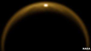 A photo from Cassini shows sunlight reflecting from a giant lake of methane on the northern half of Saturn's moon Titan