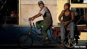 Two Cuban workers on a tricycle in Havana