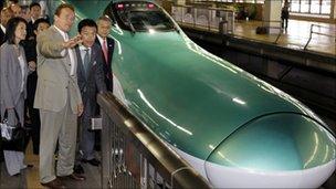 Arnold Schwarzenegger and East Japan Railway's Vice President Masaki Ogata stand beside a "shinkansen" bullet train