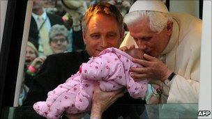 The Pope kisses a baby as he arrives in Hyde Park