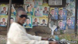 A man races past election campaign posters on his motorbike in Nigeria