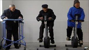 Elderly Chinese people on exercise machines at a home for the elderly in Jiangsu province
