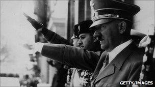 Circa 1944: Adolf Hitler (1889 - 1945) gives the fascist salute at a parade during WWII. Visible on the balcony with him are Galeazzo Ciano and Italian Benito Mussolini (far left).
