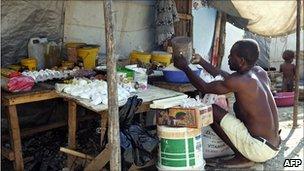 A man prepares food at a camp in Port-au-Prince, Haiti (10 Sept 2010)