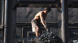 A Chinese miner unloads coal from a train in Hefei, in eastern China's Anhui province
