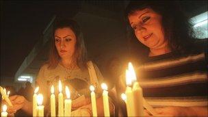 Catholics light candles at a church in Baghdad. Photo: October 2010