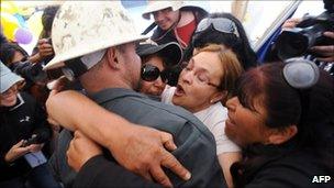 Relatives of the trapped miners hug a drill operator (9 October 2010)