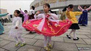 Women and children dance at the Party Foundation Monument in the North Korean capital of Pyongyang,