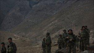 Afghan soldiers stand guard near the site of a plane crash, on the mountain side above them, east of Kabul, Afghanistan, Wednesday Oct. 13, 2010.