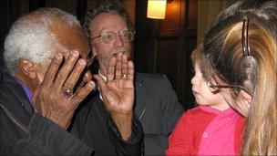 Archbishop Tutu playing peek-a-boo with David Epstein's son