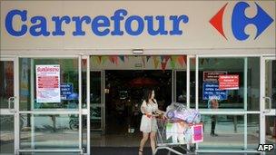 A Thai shopper leaving a French retail giant Carrefour supermarket in Bangkok