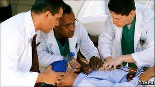 Three doctors treat a man on stretcher
