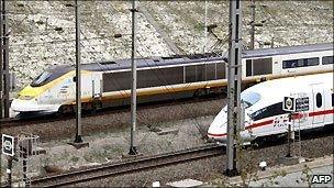 A German ICE high-speed train (white) crosses an Eurostar train before entering the Channel tunnel