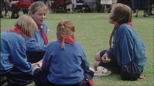 girl guides sitting on grass