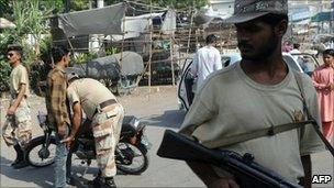 Pakistani paramilitary soldier frisks a motorcyclist in Karachi