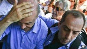 Jose Serra holds his head after being struck by an object on 20 October