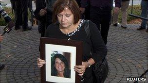 Roxanne Lloyd carrying a photograph of her daughter Jessica