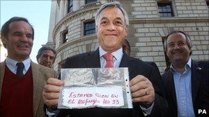 Chilean President Sebastian Pinera in London holding the note written by miner Jose Ojeda