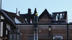 Firefighters inspect the back of the 15th Century Booth Hall pub in Hereford