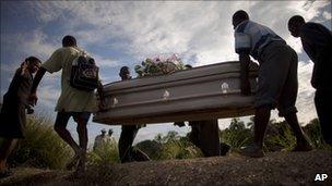 People carry a coffin containing the remains of a relative who died of cholera in Robine, Haiti (23 October 2010)