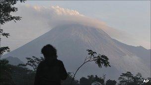 A man watches Mount Merapi as seen from Kaligendol, Yogyakarta, Indonesia, Wednesday, Oct. 27, 2010