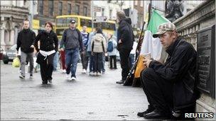 A homeless man sits on O'Connell Bridge in the centre of Dublin