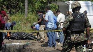 Mexican police remove a body buried in a field at Tuncingo
